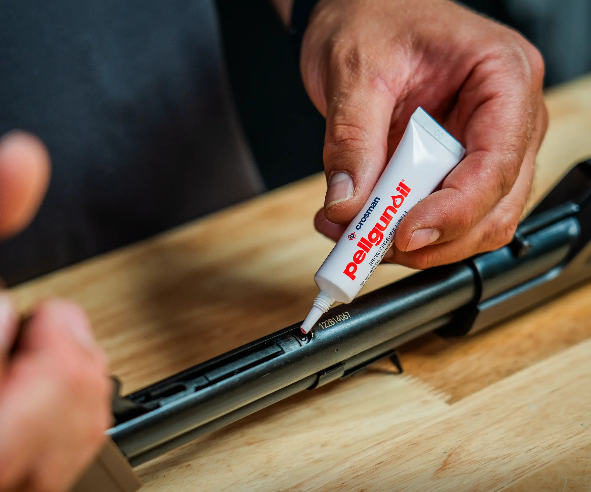 Crosman Pullgun Oil 2401 Indoor Lifestyle Applying to Breech on Bench