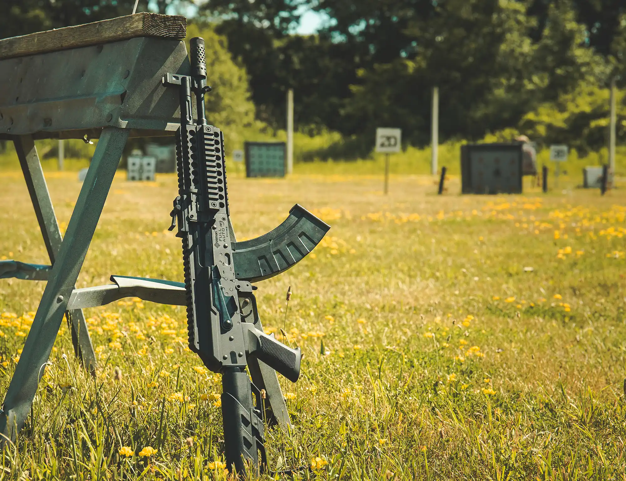 Crosman® Full Auto AK1 (BB) CAK1 Outdoor Lifestyle Leaning on a Sawhorse on a Sunny Day